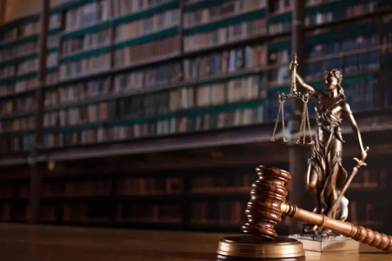 Estátua da Justiça e martelo em escritório jurídico